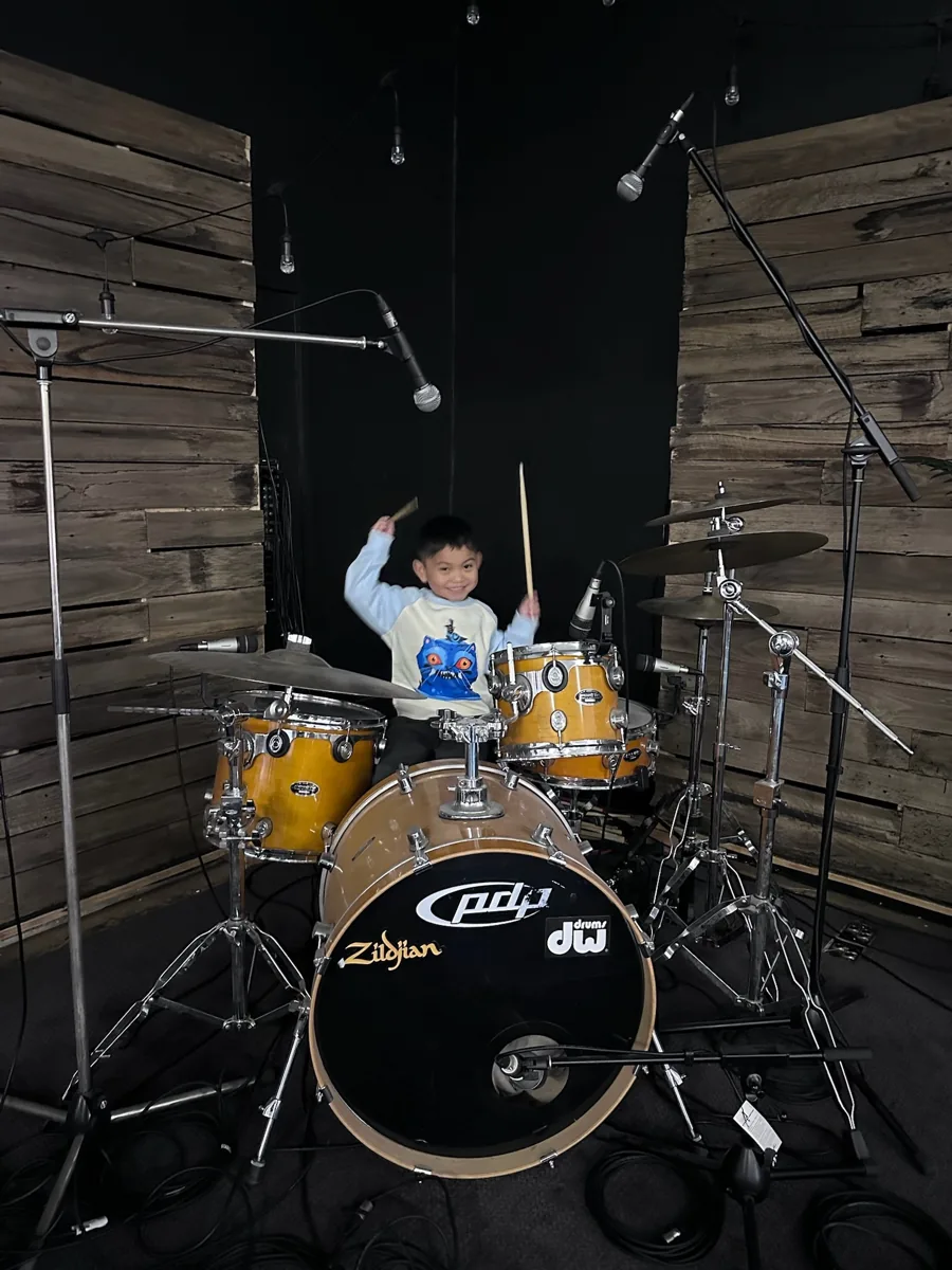 A child joyfully playing the drums