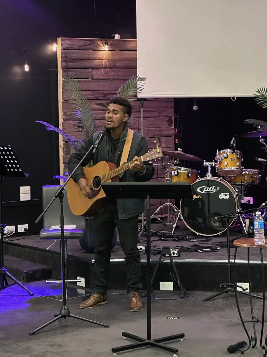 A musician leading worship at Moe New Life